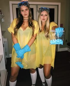 two women dressed in yellow and blue are posing for the camera with gloves on their hands