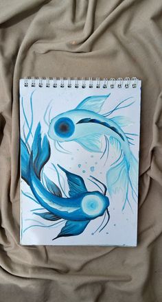 a drawing of a blue fish on a sheet of paper with watercolor pencils