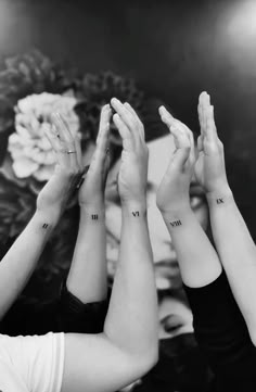 three women are holding their hands up in the air