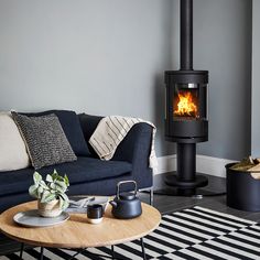 a living room filled with furniture and a fire place in the middle of the room