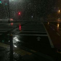 an empty crosswalk in the rain at night