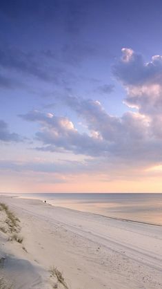 an empty beach with the ocean in the background