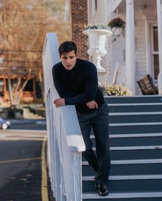 a man leaning on the side of a white railing