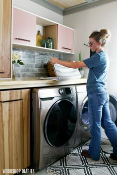 a woman is doing something in the washer