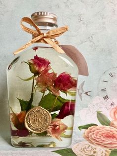 a glass bottle with flowers in it sitting on a table