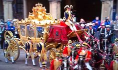 a group of men in uniform riding on the back of a horse drawn carriage