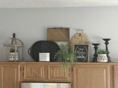 a kitchen with wooden cabinets and plants on the top shelf above the refrigerator freezer