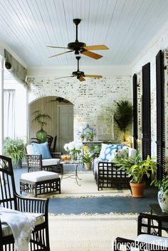 an outdoor living area with wicker furniture and ceiling fan