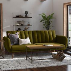 a living room with a green couch and coffee table in front of a large window