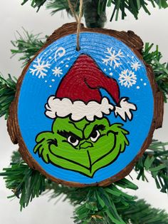 an ornament hanging from a christmas tree with the grin face painted on it