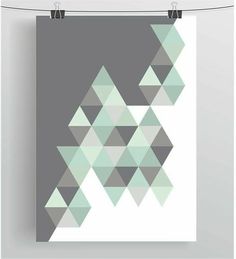 a poster hanging on a clothes line with an abstract design in grey and mint green