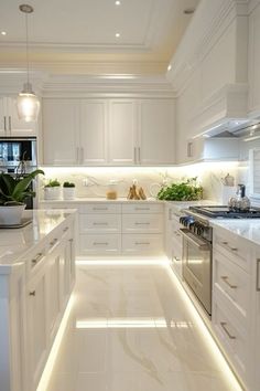 a kitchen with white cabinets and lights on the counter tops, along with an island