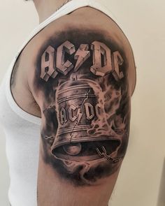 a man with a tattoo on his arm that reads ac dc and has a bell in it