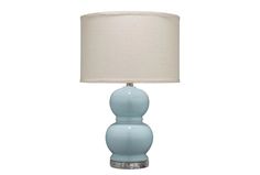 a light blue lamp with a white shade on it's base and a beige linen lampshade