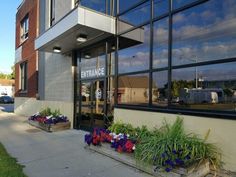 the entrance to an office building with flowers in front