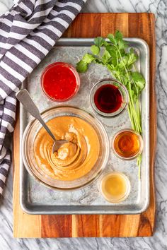 an overhead shot of sauces and condiments on a cutting board with a striped towel