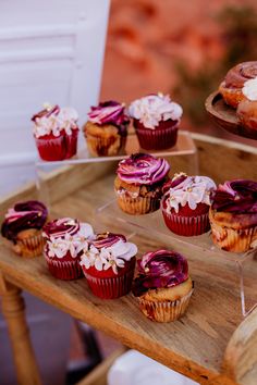 cupcakes and pastries are displayed on trays