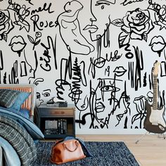 a bedroom with black and white graffiti wallpaper