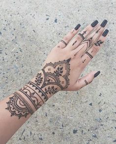 a woman's hand with henna tattoos on it