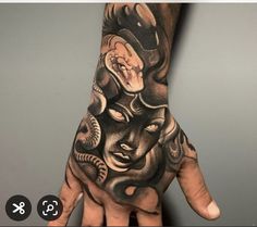 a person's hand with a tattoo on it and an image of a demon