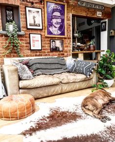 a living room filled with lots of furniture and pictures on the brick wall above it