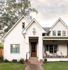 a white house with brick walkway leading to the front door