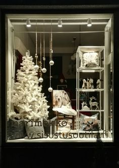 a white christmas tree sitting inside of a window