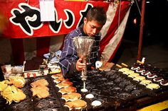 a man standing over a table filled with cookies and crackers on top of it