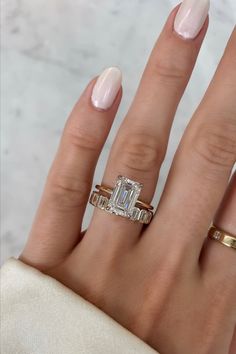 a woman's hand with two gold rings and a diamond ring on her finger