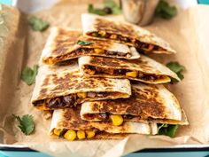 several quesadillas stacked on top of each other with toppings and garnishes