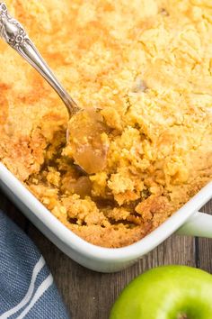 a spoon in a casserole dish with an apple