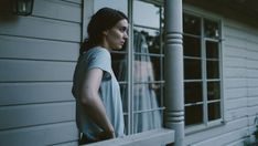 a woman looking out the window of a house