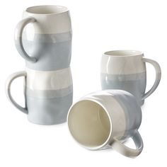 two white and grey coffee mugs next to each other on a white surface with one cup in the middle