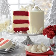 a red and white cake sitting on top of a glass plate next to a christmas tree