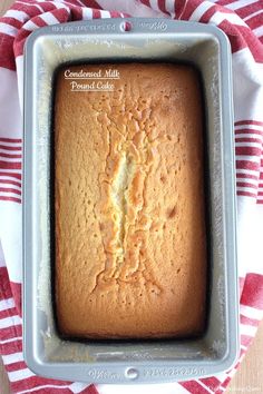 a loaf of pound cake sitting in a pan on a red and white striped towel