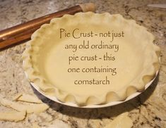 a pie sitting on top of a counter next to a wooden spatula with writing on it