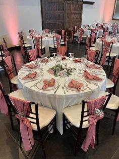 the tables are set with pink napkins and place settings for guests to sit at