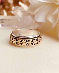 two wedding rings sitting on top of a table next to flowers