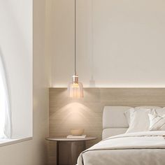 a white bed sitting next to a window with a light hanging from it's side