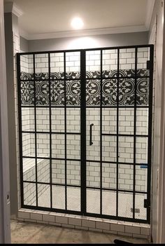 an open glass door leading to a bathroom with tiled walls and flooring in the background