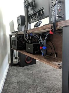 a computer desk with many wires on it