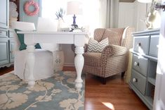 a living room filled with furniture and a white table in front of a large window