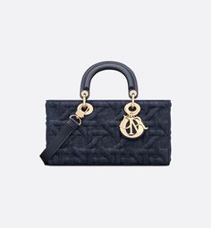 The Lady D-Joy bag captures the House's vision of elegance and beauty by showcasing the iconic streamlined aesthetic of the Lady Dior line. Crafted in blue denim, the style features the Graphic Cannage motif, offering a modern 3D version of the House icon. Pale gold-finish metal D.I.O.R. charms embellish and illuminate its silhouette. Equipped with one removable chain strap and another adjustable and detachable leather strap, the medium Lady D-Joy bag can be carried by hand, worn over the should Luxury Denim Blue Shoulder Bag For Travel, Luxury Denim Blue Shoulder Bag For Daily Use, Luxury Denim Blue Bag For Daily Use, Modern Denim Blue Bag For Everyday Use, Designer Denim Blue Bags, Luxury Navy Bags With Double Handle, Luxury Navy Bag With Double Handle, Luxury Navy Double Handle Bag, Luxury Navy Shoulder Bag With Top Carry Handle