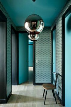 a chair sitting in the middle of a hallway next to a blue wall and door