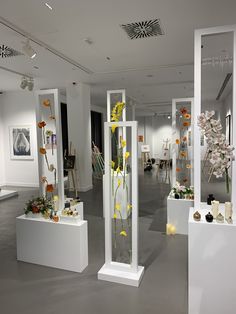 a room filled with vases and flowers on display