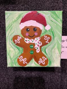 a painting of a gingerbread man wearing a santa hat and holding a candy cane