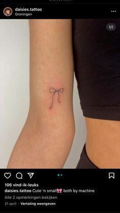 a small bow tattoo on the arm