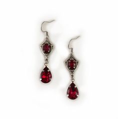 These dainty and elegantly ornate earrings are made with antique silver plated centerpieces, and silver tone settings, worn with stainless steel earring hooks. They are accented with deep ruby red glass crystals/jewels. Earrings measure 2 1/8" in length (including earring hooks) and 1/2" wide. More colors are available in our shop, along with matching chokers.If you don't see items with a color you want, feel free to ask about availability. Ornate Earrings, Dark Red Earrings, Medieval Steampunk, Gothic Antique, Ornate Necklace, Victorian Gothic Jewelry, Victorian Accessories, Rockstar Aesthetic, Stylish Earrings