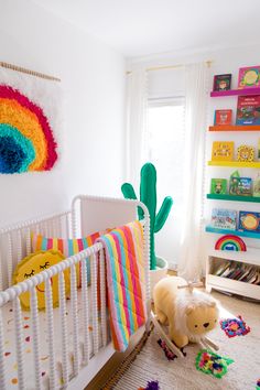 a white crib in a child's room with toys on the floor