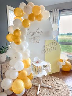 a baby's 1st birthday party with yellow and white balloons in the shape of a arch